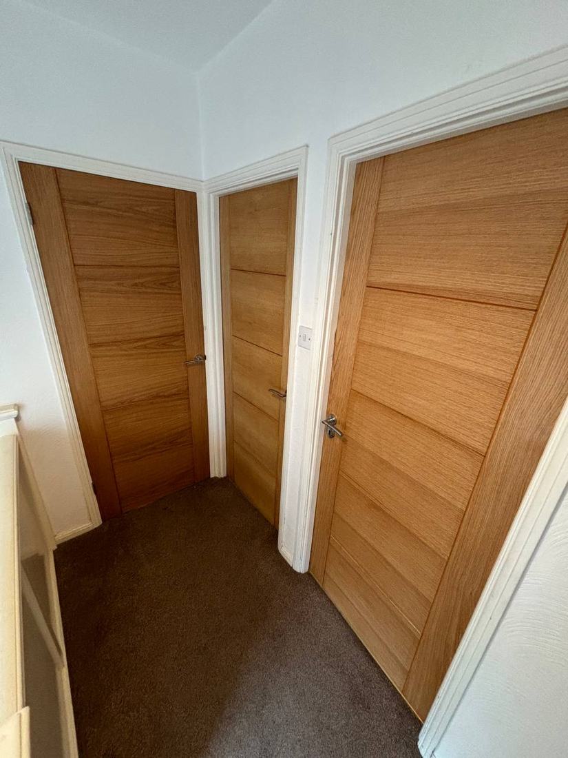 Three oak ladder-style internal doors on a landing