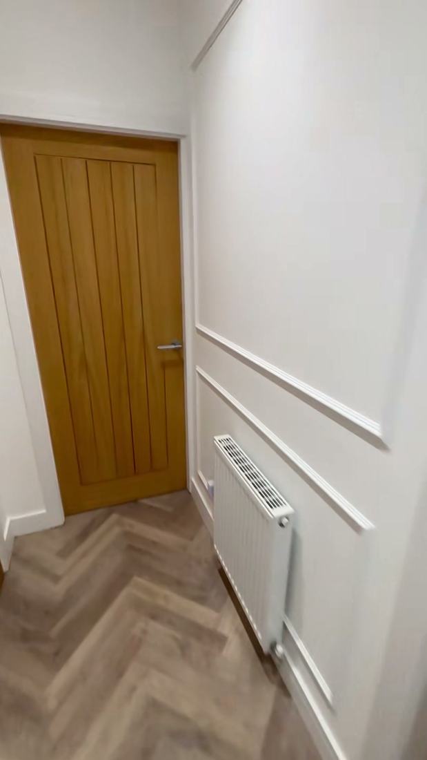Oak door with painted wall panelling and herringbone flooring