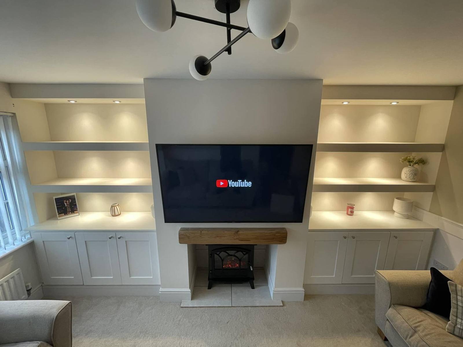 Bespoke alcove units and media wall with lit floating shelves, built by CPB Carpentry in Leicester